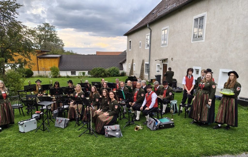 Trachtenkapelle spielt vor historischem Gebäude in Oberösterreich