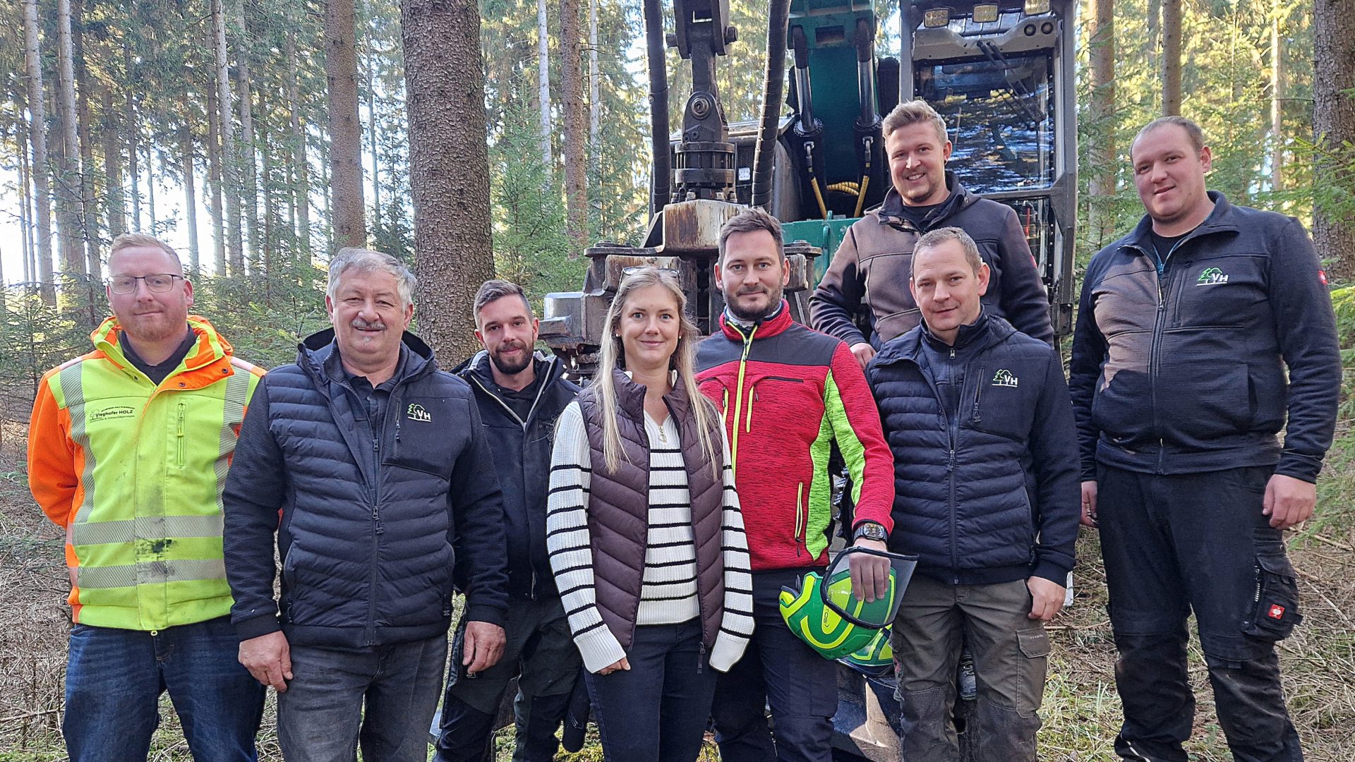 Forstarbeiterteam mit Harvester im Wald in Österreich